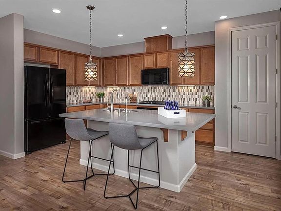 kitchen with large pantry, center island sink, plenty of storage space in beautiful custom cabinets and drawers, designer backsplash, door on left is to garage.