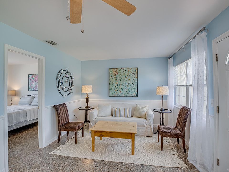 Large furnished living room with terrazzo floor, adjacent to two bedrooms