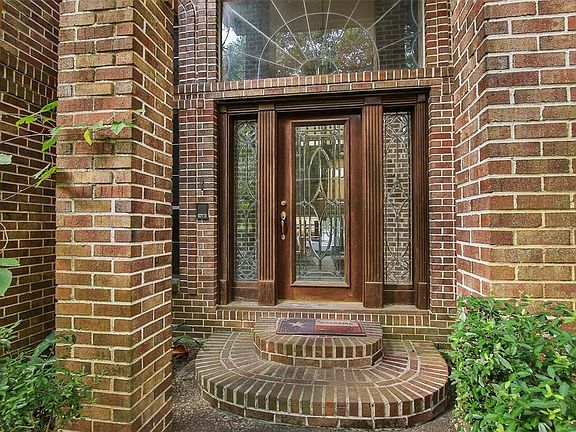 The elevated entry showcases the beautiful beveled glass door and windows, and wooden accents.