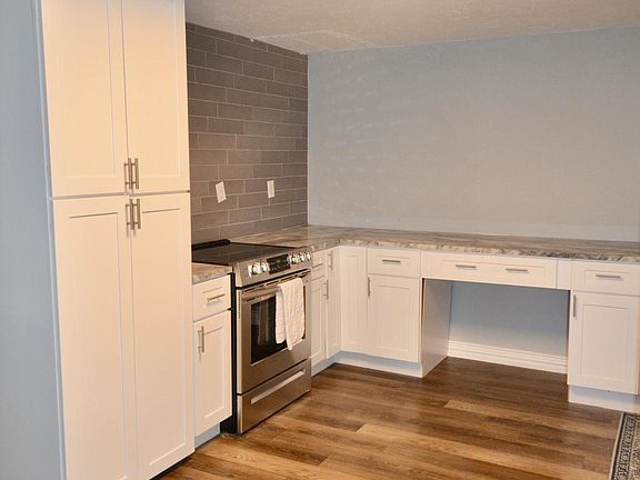 Kitchen has large pantry for storage at left and built in desk to right.