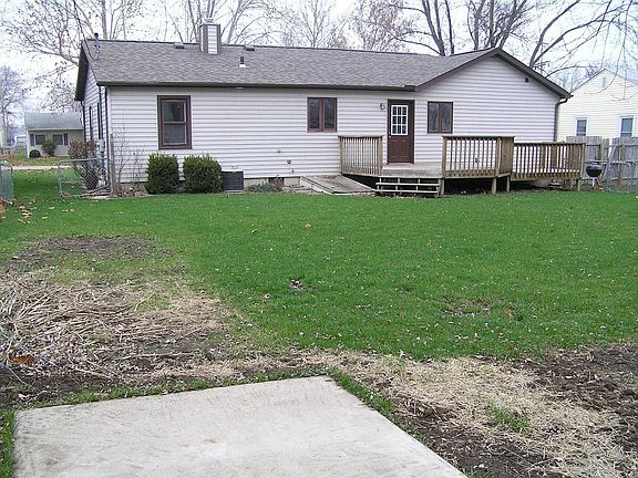 back yard showing garden, concrete dog pad, and large deck