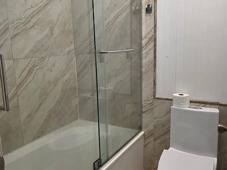 Bath 2 - tub and Floor to wall large tiles, single piece toilet with dual flush