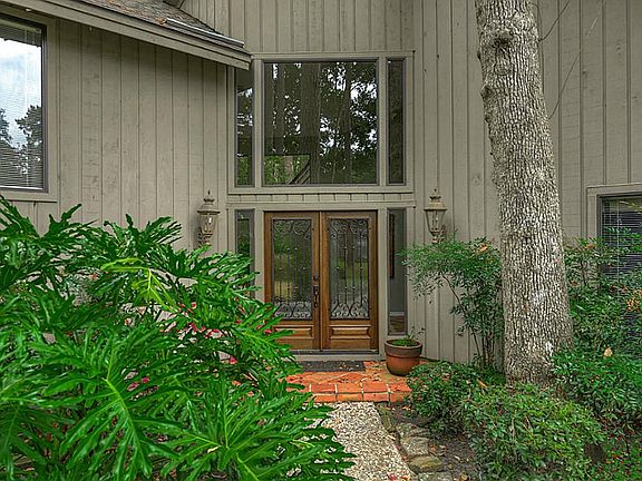 Beautiful custom iron and wood entry doors greets you as you approach.