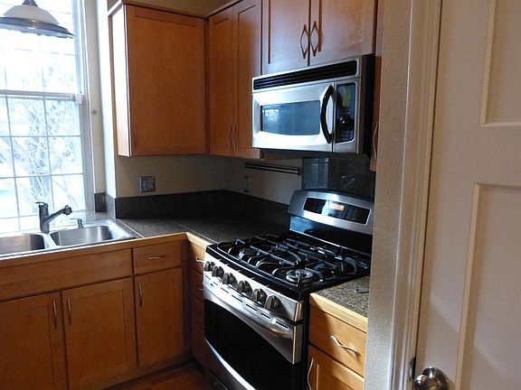 The kitchen features stainless steel range with a natural gas cooking surface.