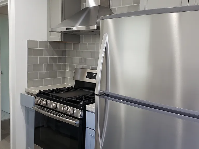 Kitchen appliances, and door leading towards hall.