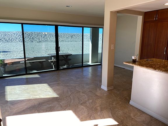 living room and dining area with kitchen island on the right. a view of the patio.