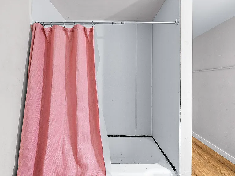 Simple tub-and-shower setup with a curtain rod and easy-to-maintain surround for everyday use.