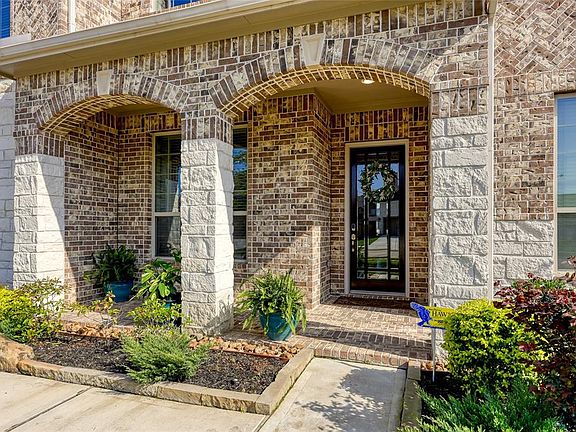 Wander up the pathway to an arched covered porch, ideal for relaxing with a glass of iced tea and waving to the neighbors as they pass by!