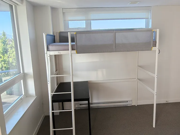 2nd bedroom semi-furnished with a loft bed and desk.