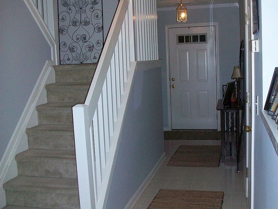 View of the stairs and front door from living room