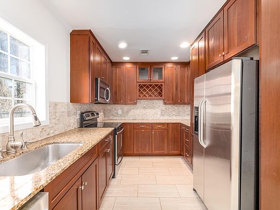 Enjoy cooking in this bright kitchen--shaker cherry cabinets, silestone counters, and stainless steel appliances make storing, prepping, and cleaning up meals a breeze!