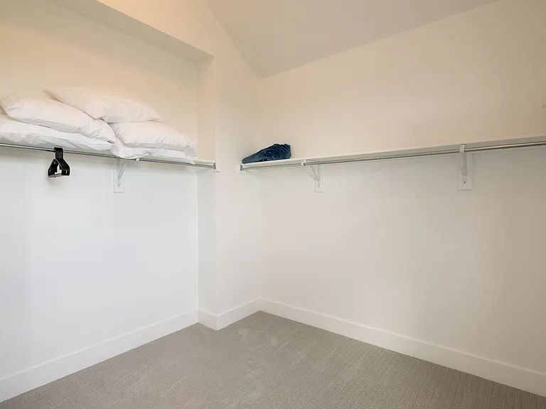 Primary bedroom has a large walk-in closet with extra pillows available for use