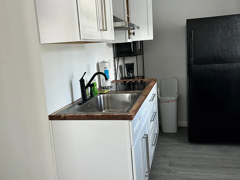 Fully equipped kitchen with cabinets, fridge & essentials.