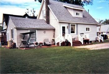 A side view showing the side porch and entry door into the diningroom. Also the patio in front of what used to be a 1car attached garage, now used for a mudroomworkshop. There is the possiblity of making this room into a 1st floor bedroom?