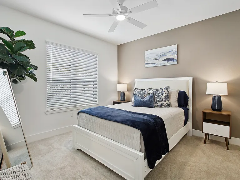 Bright and inviting bedroom with elegant decor, featuring a plush bed, modern art, and abundant natural light.