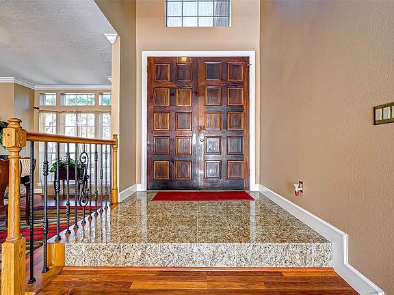2-story entrance hall with tile flooring opening up to the formal dining room.