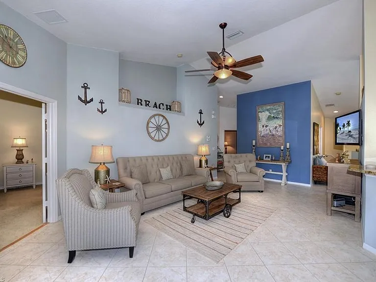 Bright living room with open layout, comfortable seating, and views to the lanai.