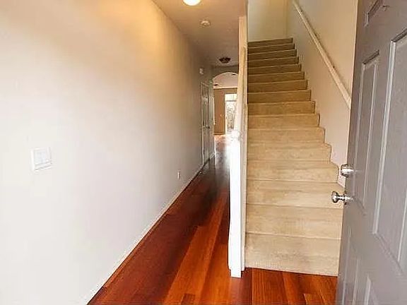 Entry hallway with hardwood-style flooring and staircase to the upper level.