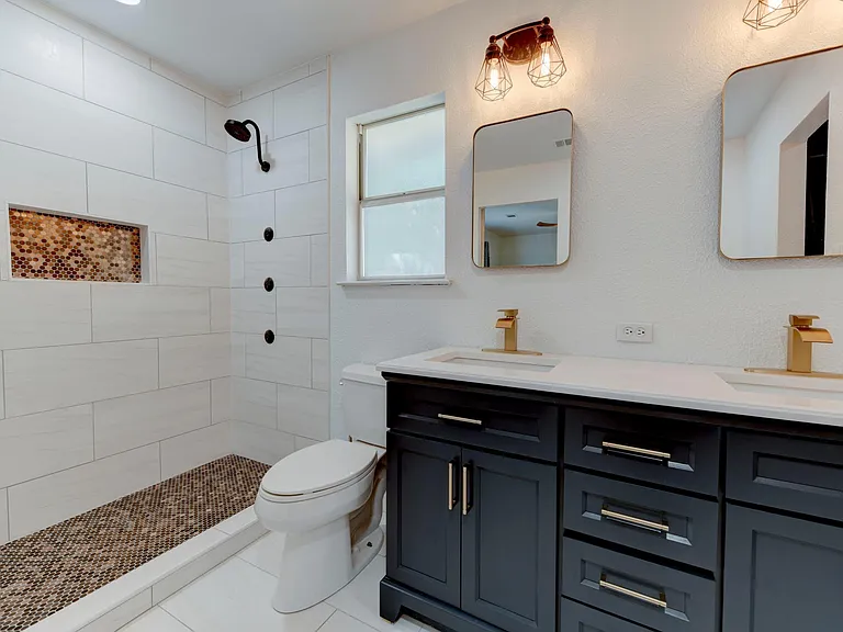 Dual vanity w/ recessed mirrors and rustic lighting.
