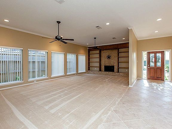 Huge living area with builtins, high ceilings, and wall of windows.