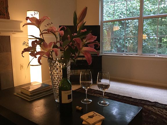 The entire living and dining areas feature large windows overlooking a peaceful wooded area.