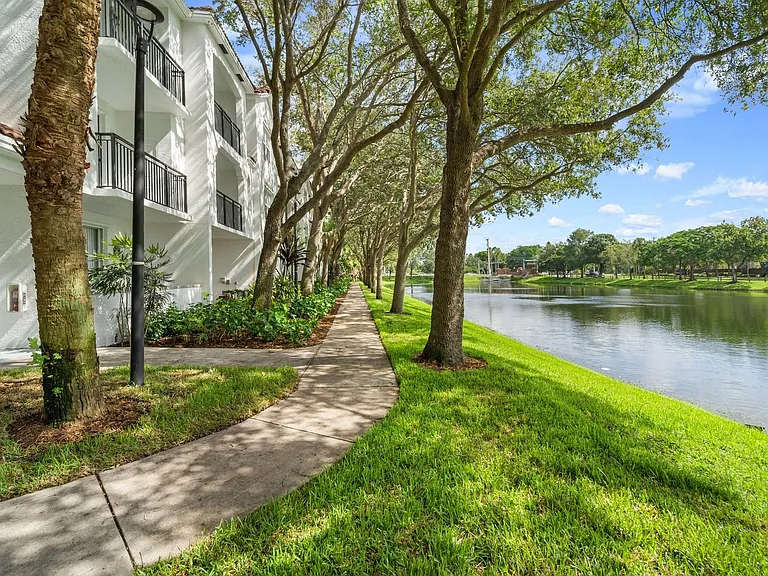A path with great landscaping and a lake