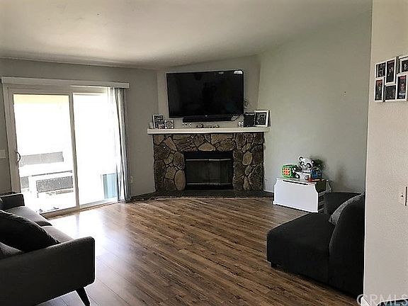 Living room, rock, gas fireplace, and new laminate floors. Dual pane slider leading to covered patio