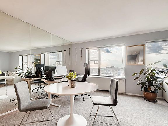 MIrrored wall in living room creates light and roomy feel. View of North loop and Twins Stadium.