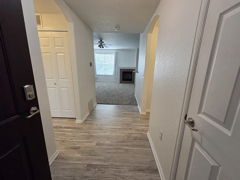 Spacious entrance hall, coat closet on right and hall to kitchen/primary bed & bath, hall with washer/dryer, guest bath and guest room on the left.