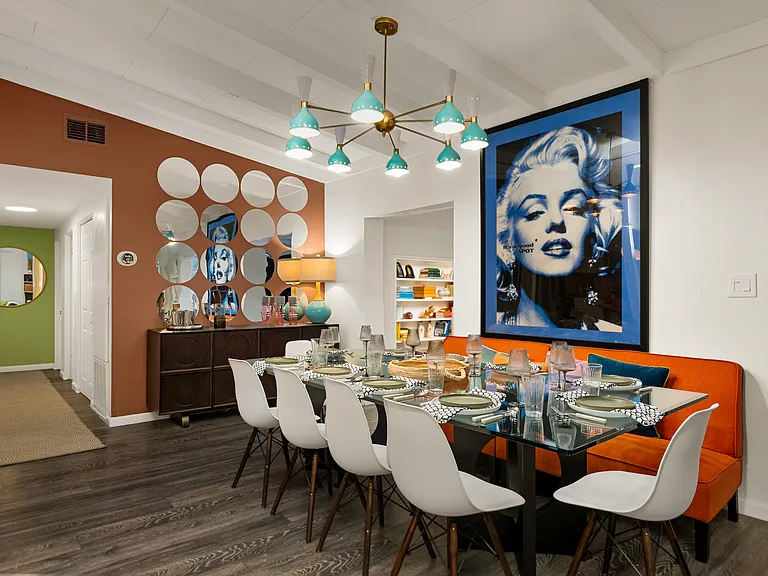 View of dining room from living room. Dining table seats ten. Matching dish ware, flat ware, and glasses are also provided. The room also has a large buffet and dimmable overhead light.