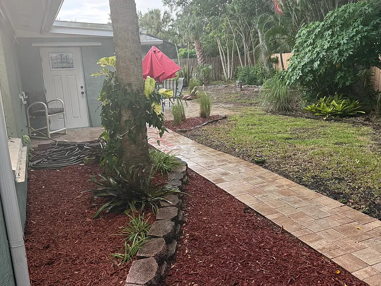Paver walkway in backyard. Backyard door.