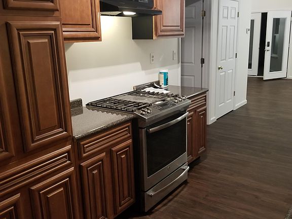 New custom cabinets. Gas/propane range. Looking from back of house to front doors. Open door on the left is the bedroom. Closed door on the left is the half bath.