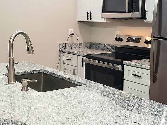 Open kitchen with island big enough to accommodate 4 bar stools. Equipped with all new stainless steel appliances and granite counter tops.