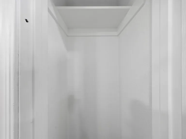 Dedicated closet nook with a shelf and hanging space, offering convenient in-room storage for clothing and essentials.