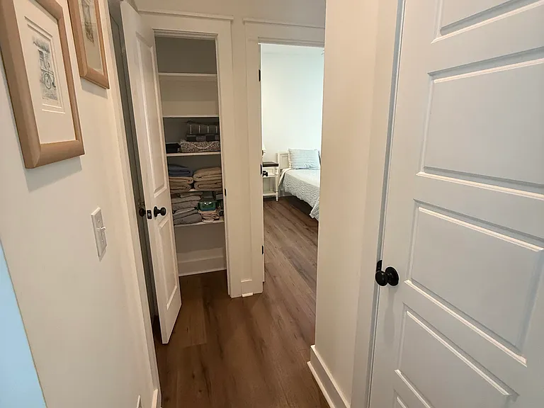 Hallway from kitchen, large pantry door on right, linen closet before master bedroom and hallway bathroom on the right