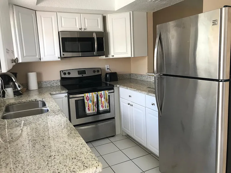 Updated kitchen with granite countertops, stainless steel appliances and lazy susan. U shaped layout with serve through window is great for cooking with chatting with guests in the dining room.