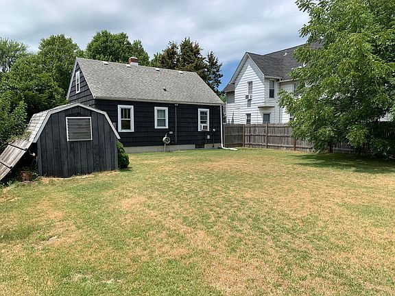 Standing at the back of the yard.