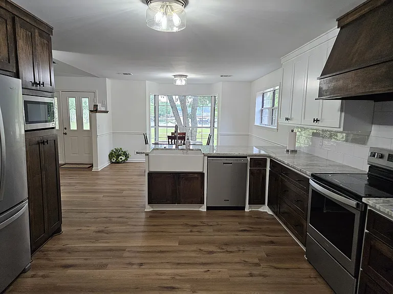 View of kitchen and dinning room from the laundry room. Bay window with view to Lake Hamilton. New or newer appliances.