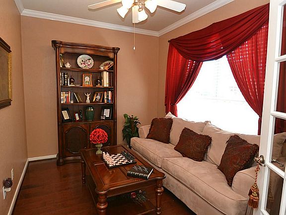 French doors open to the study accented by hardwood floors, crown molding and a ceiling fan with light fixture..
