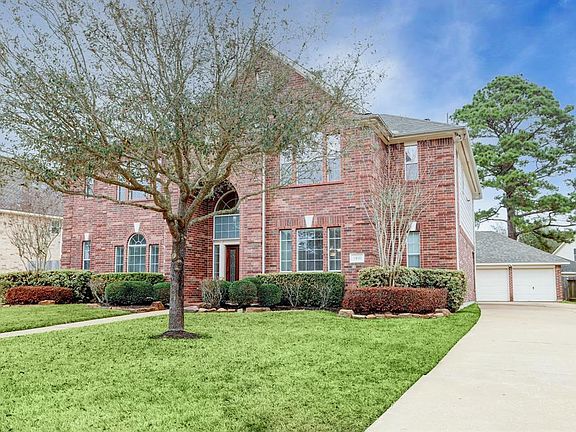 Under a covered entry is the front door featuring leaded glass. Enjoyable front space with an expansive driveway.