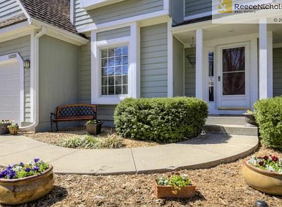 Updated landscaping and fresh mulch and pansies greet you as you