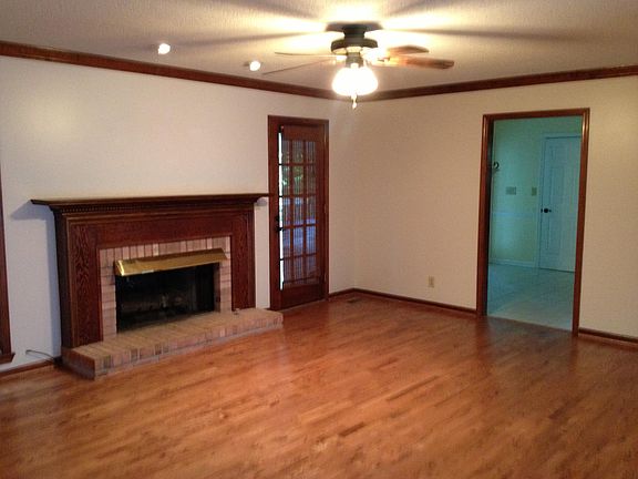 Spacious den with fireplace and hardwood floors.