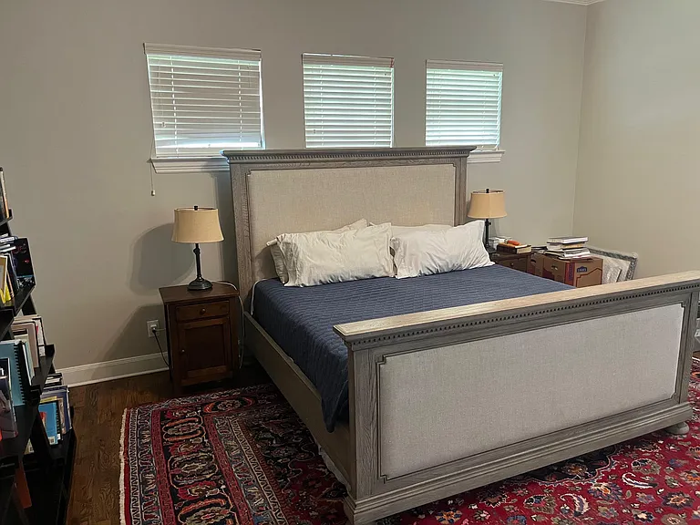 Primary bedroom with woodwood floors; sitting area and bookcase not shown