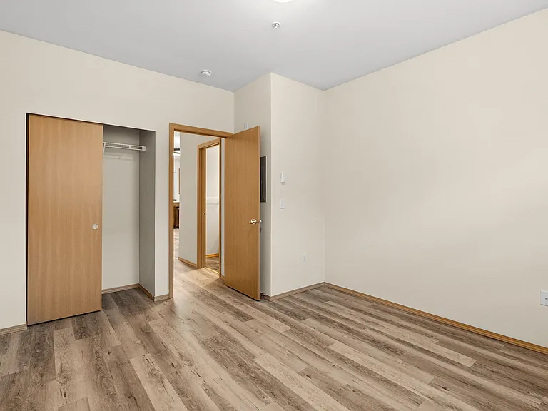 Comfortable bedroom with modern flooring and a convenient sliding-door closet. Comfortable bedroom with modern flooring and a convenient sliding-door closet.
