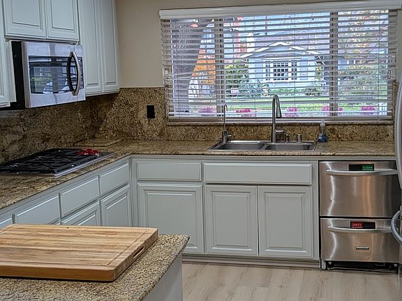 New appliances in kitchen, new flooring and freshly painted cabinets
