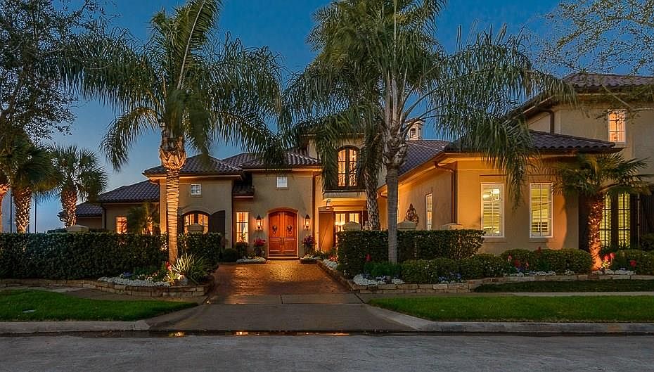STRIKING FRONT ELEVATION AT DUSK WITH PAVERED MOTORCOURT LEADING TO THE FRONT ENTRY.