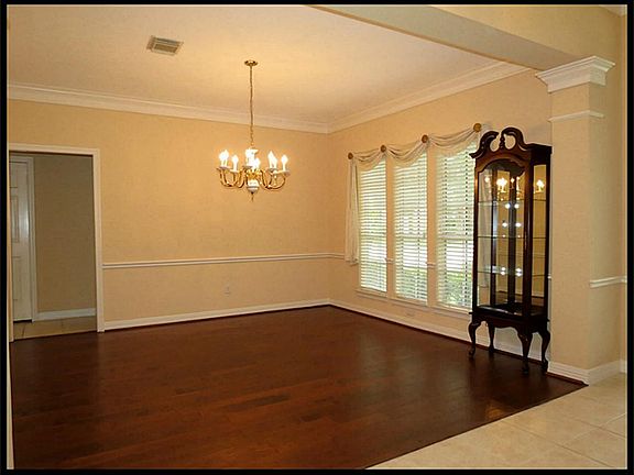 Formal dining room with hand scraped wood floors and chandelier.