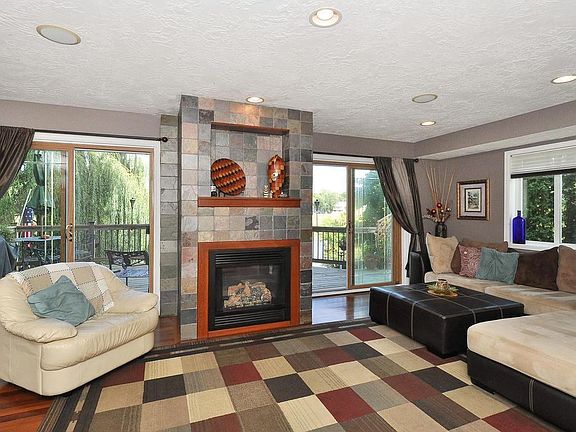 Main floor enjoys this living room PLUS main level great room! Hardwood floors and dual access to lakeside deck. Warm up to fireplace on cooler nights!