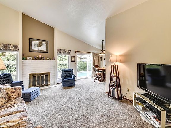 Large windows offer glimpses of the attractive backyard and swimming pool.  The fireplace is a nice focal point in the living room.  The carpet was installed in the fall of 2015.  The interior was painted between the summer of 2015 and last fall.