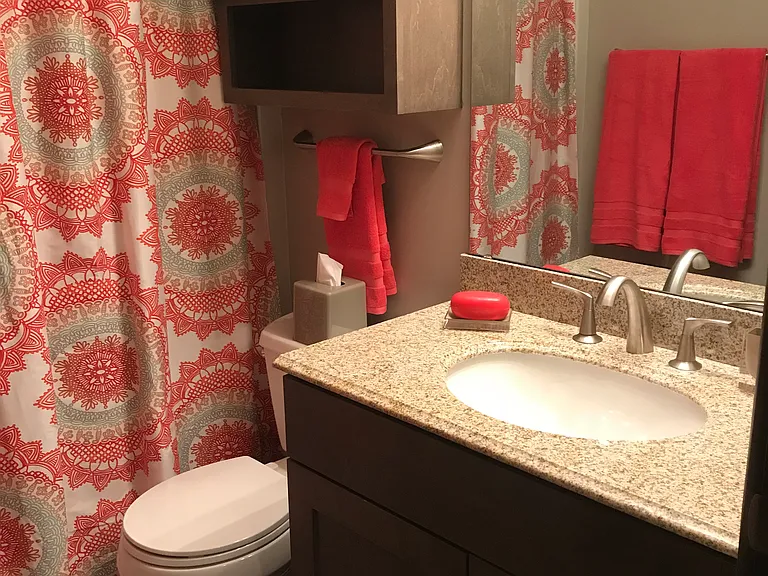 Bathroom with stone countertop and ample cabinet space
